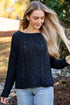 Woman wearing a black cable knit sweater outdoors