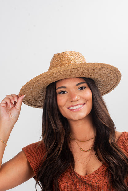 Woman wearing a straw hat against a plain background