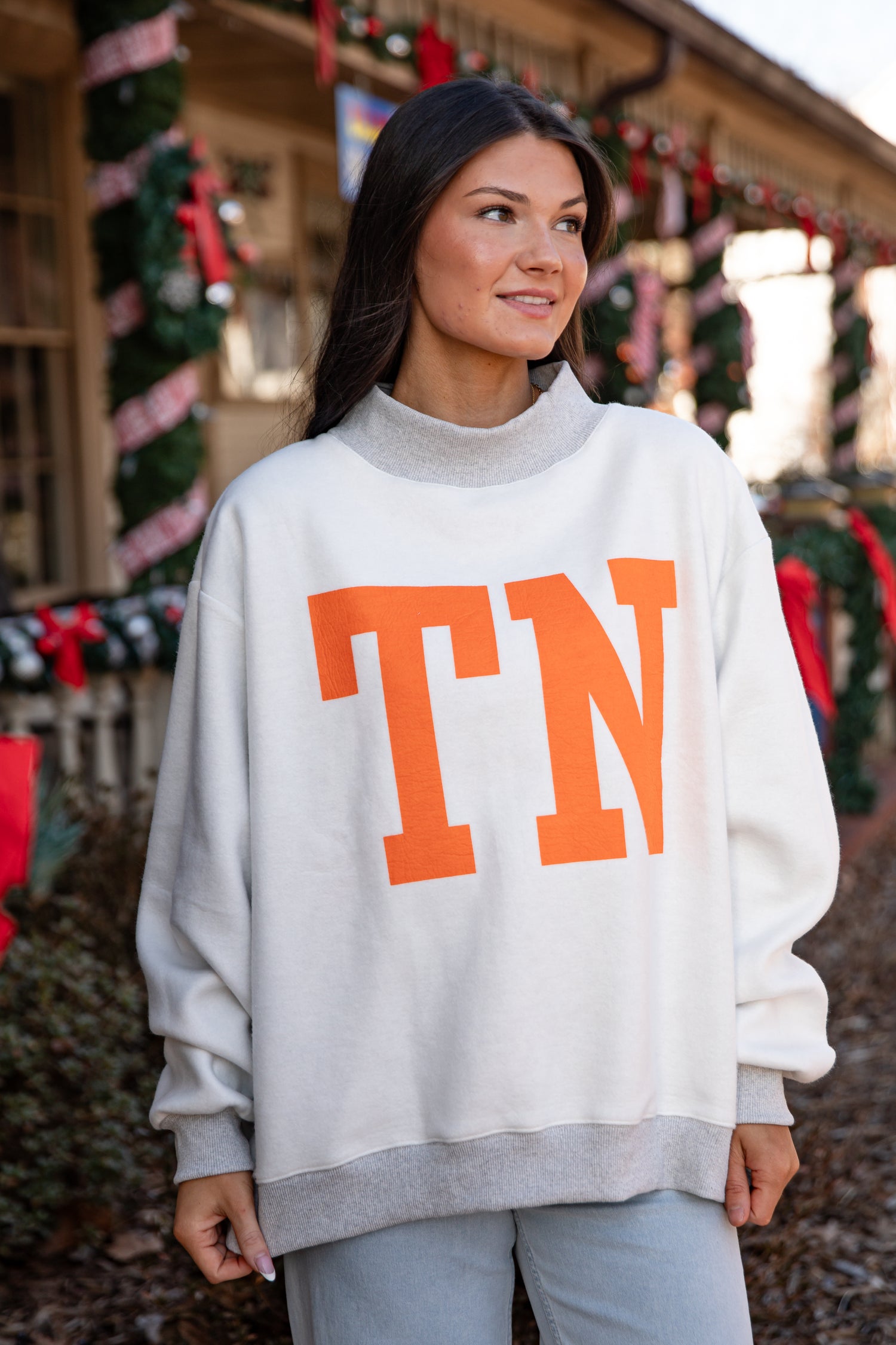 Woman wearing a white sweater with &