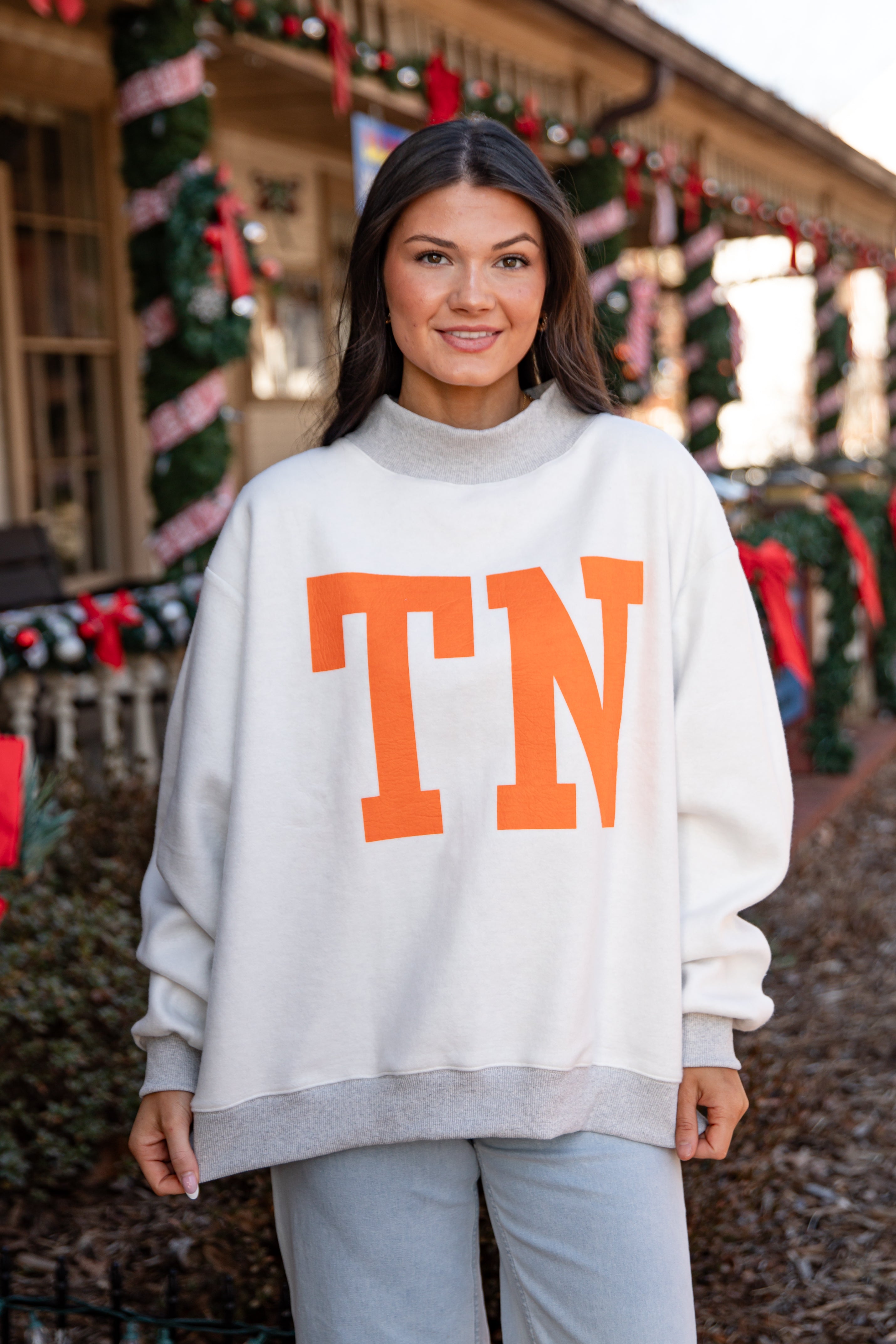 Woman wearing a white sweater with &