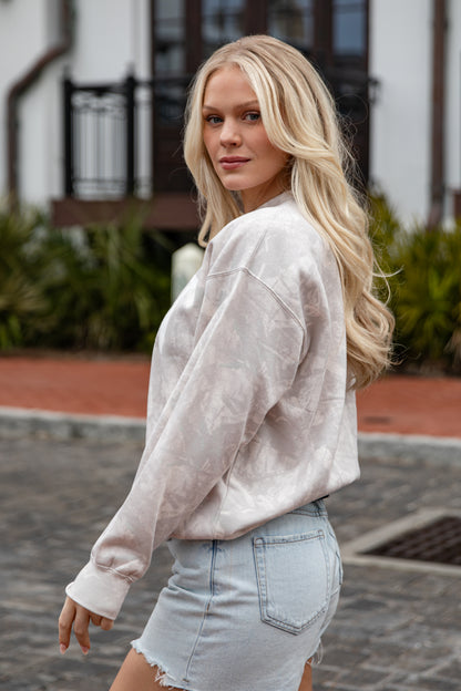 Woman wearing a light-colored jacket and denim shorts outdoors.