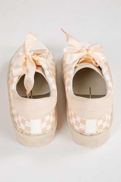 Pair of beige checkered shoes with ribbons on a white background