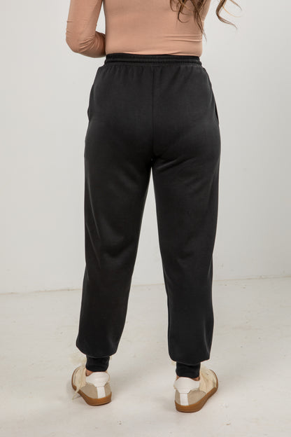 Person wearing black sweatpants on a white background