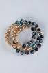 Two beaded bracelets with gold and blue beads on a light gray background