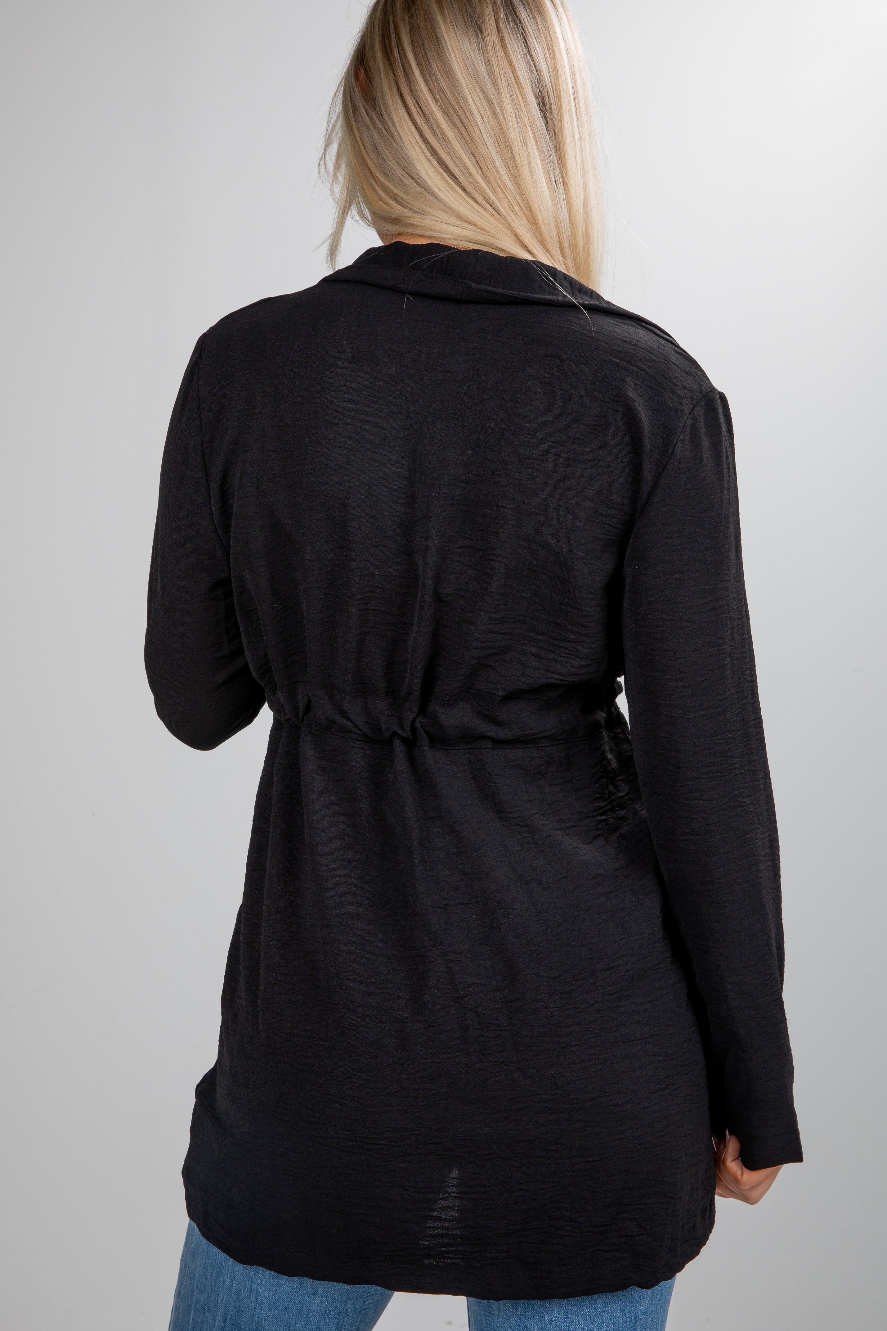 Black jacket worn by a person on a plain background