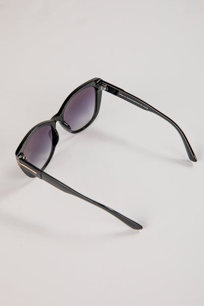Black sunglasses with purple lenses on a light gray background