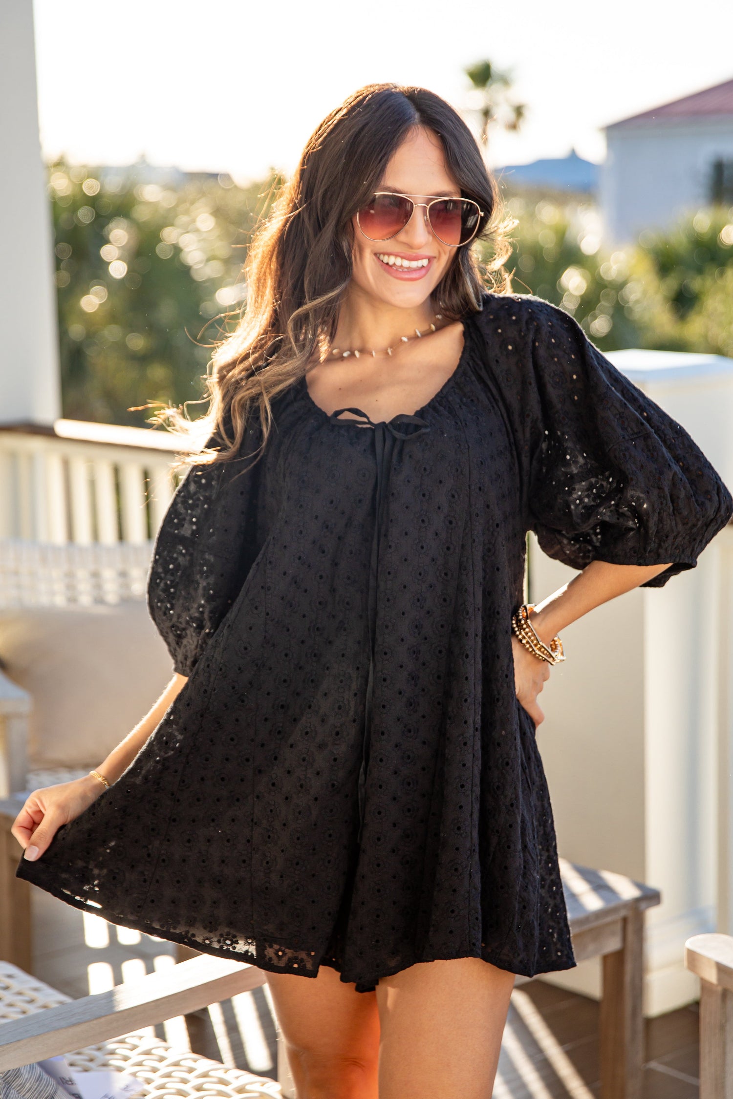 Woman wearing a black dress with puff sleeves on a balcony