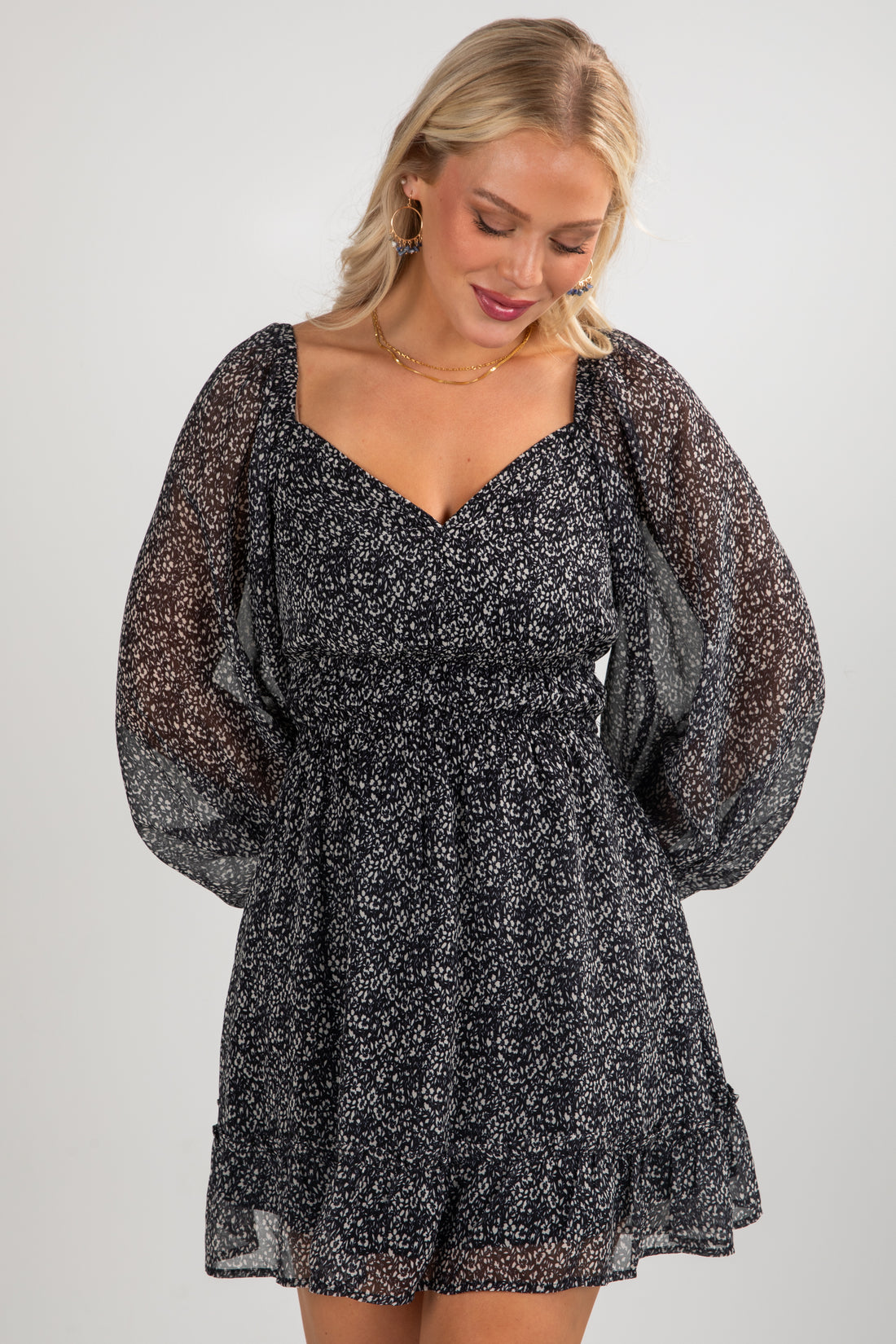 Woman wearing a black floral dress against a white background