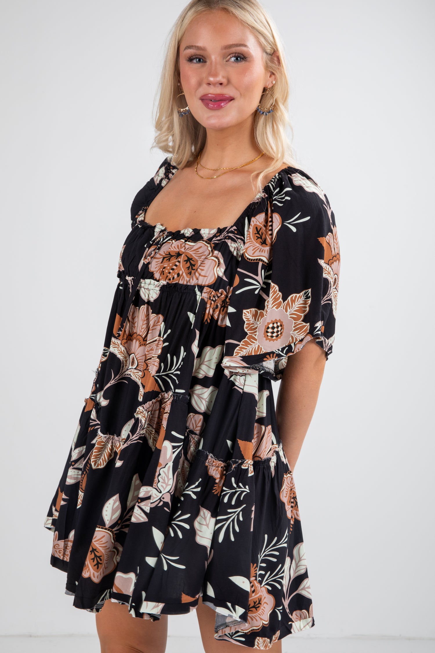 Woman wearing a black floral dress against a white background