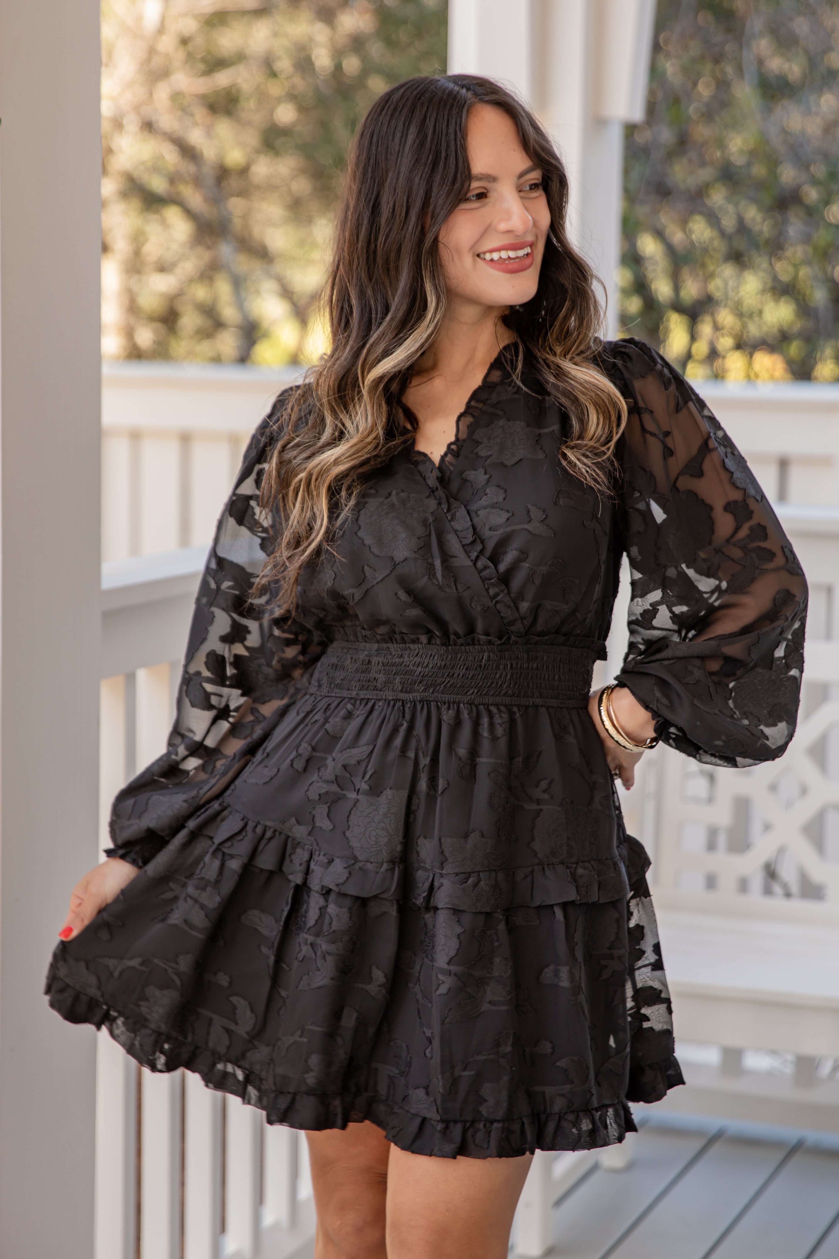 Woman wearing a black lace dress on a porch