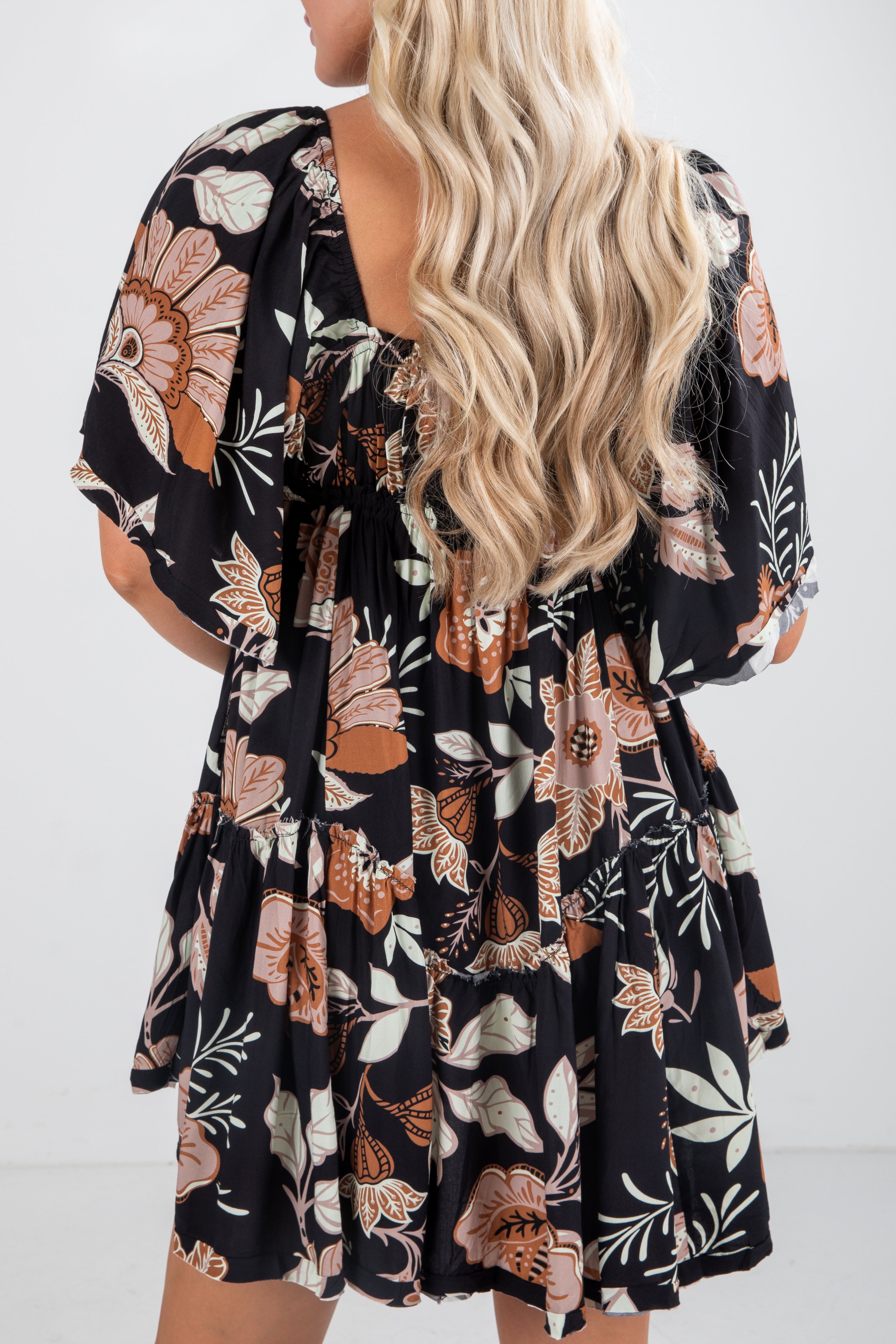 Woman wearing a black floral dress with a white background