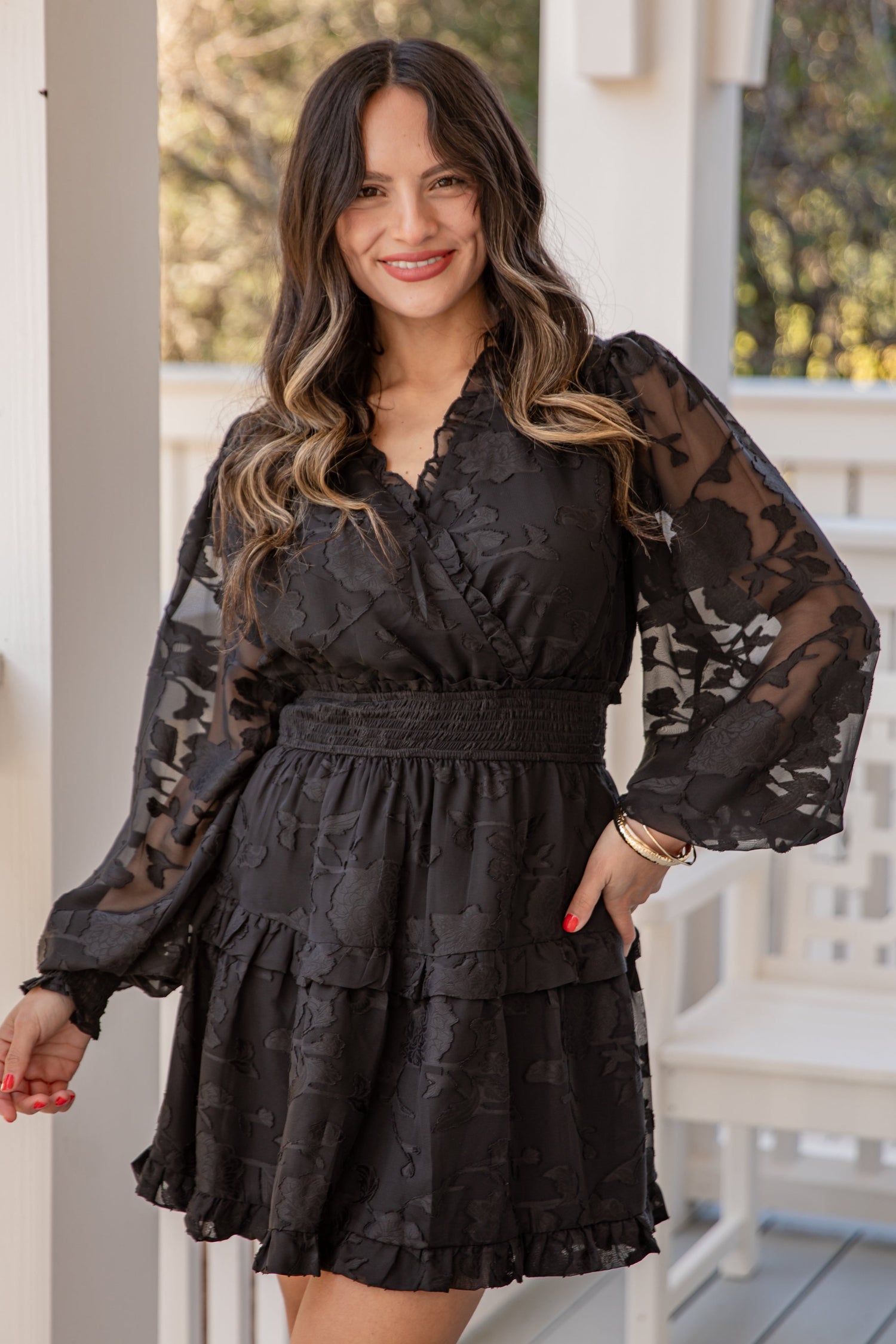 Woman wearing a black lace dress on a porch