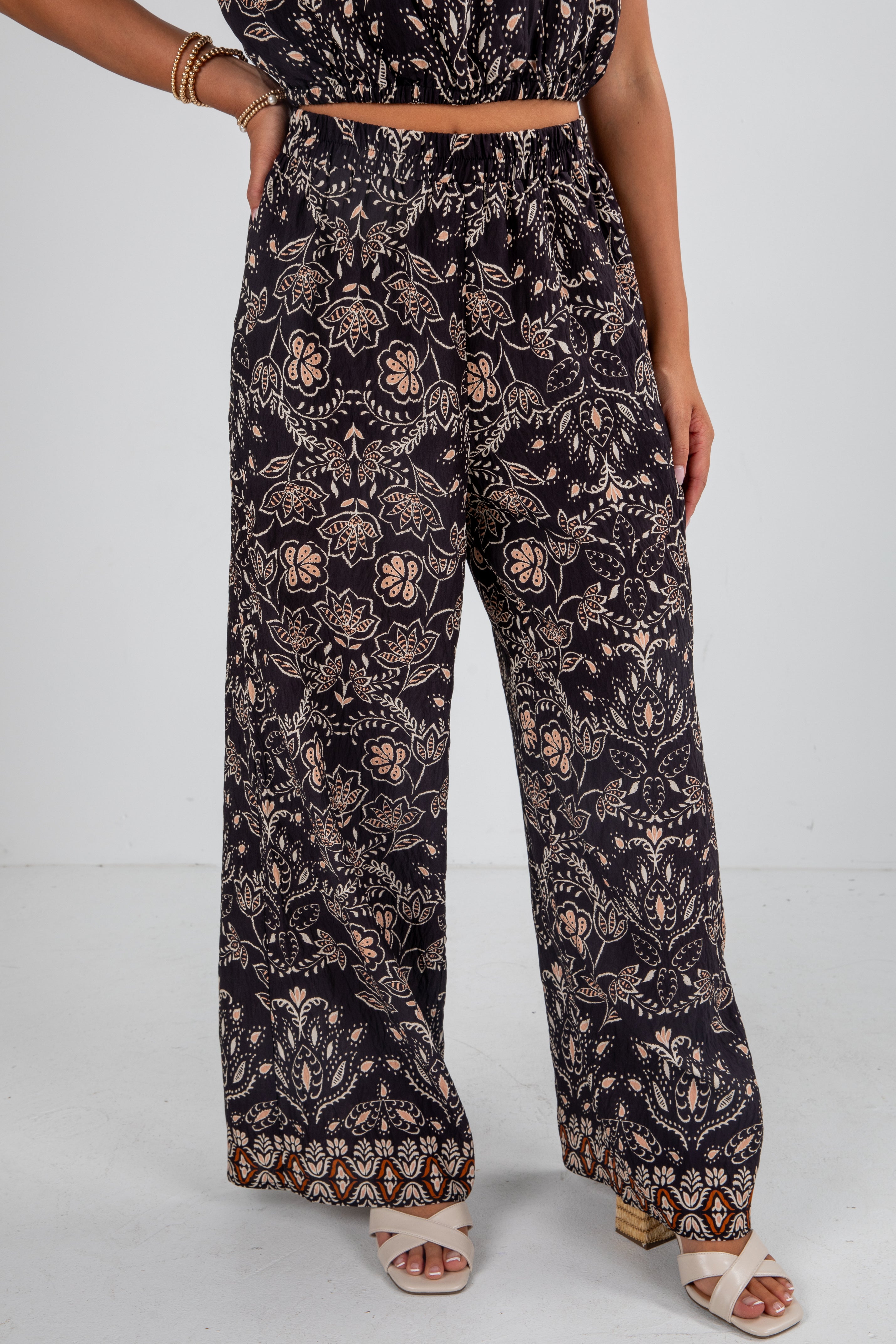 Person wearing a black floral patterned outfit on a white background