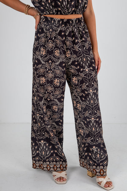 Person wearing a black floral patterned outfit on a white background