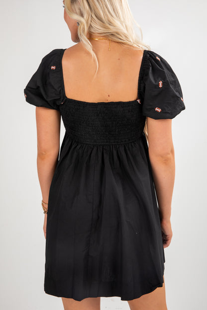 Black dress with puff sleeves worn by a person on a white background