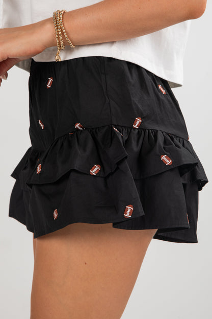 Black tiered skirt with decorative buttons on a white background