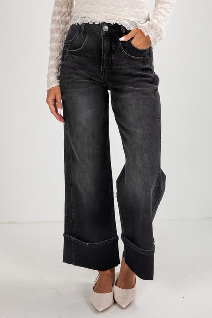 Person wearing black jeans on a white background