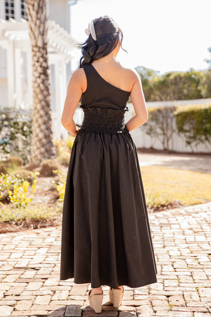 Woman wearing a black dress with a lace waist in an outdoor setting