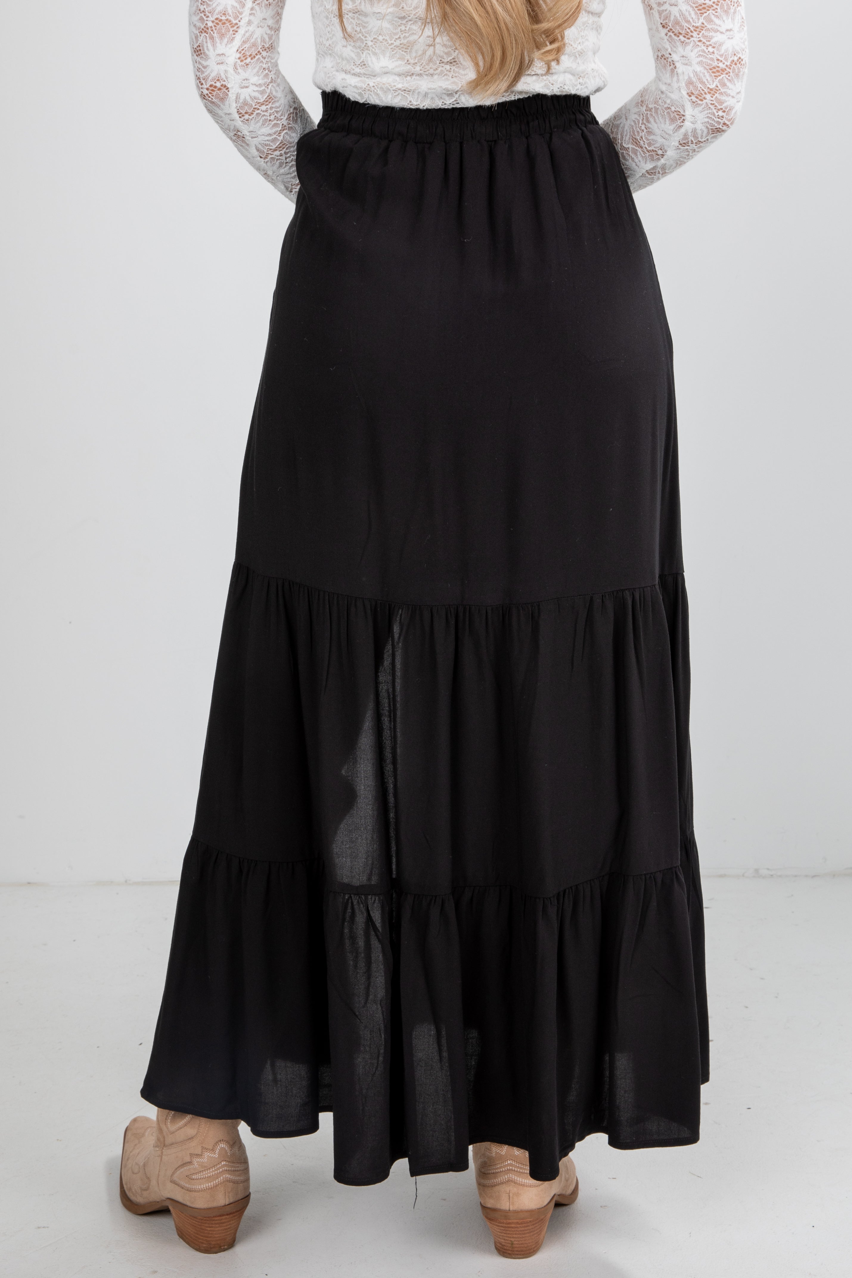 Black tiered skirt worn by a person on a white background