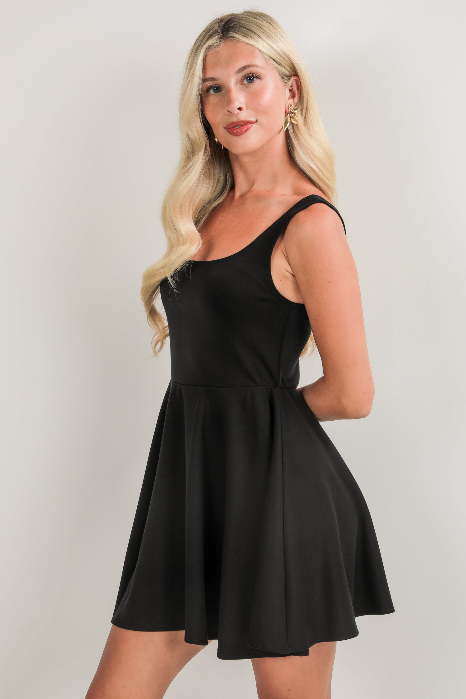 Woman wearing a black dress against a plain background