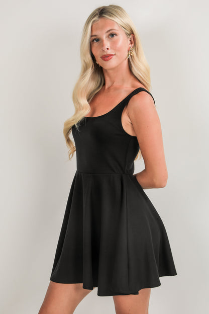 Woman wearing a black dress against a plain background