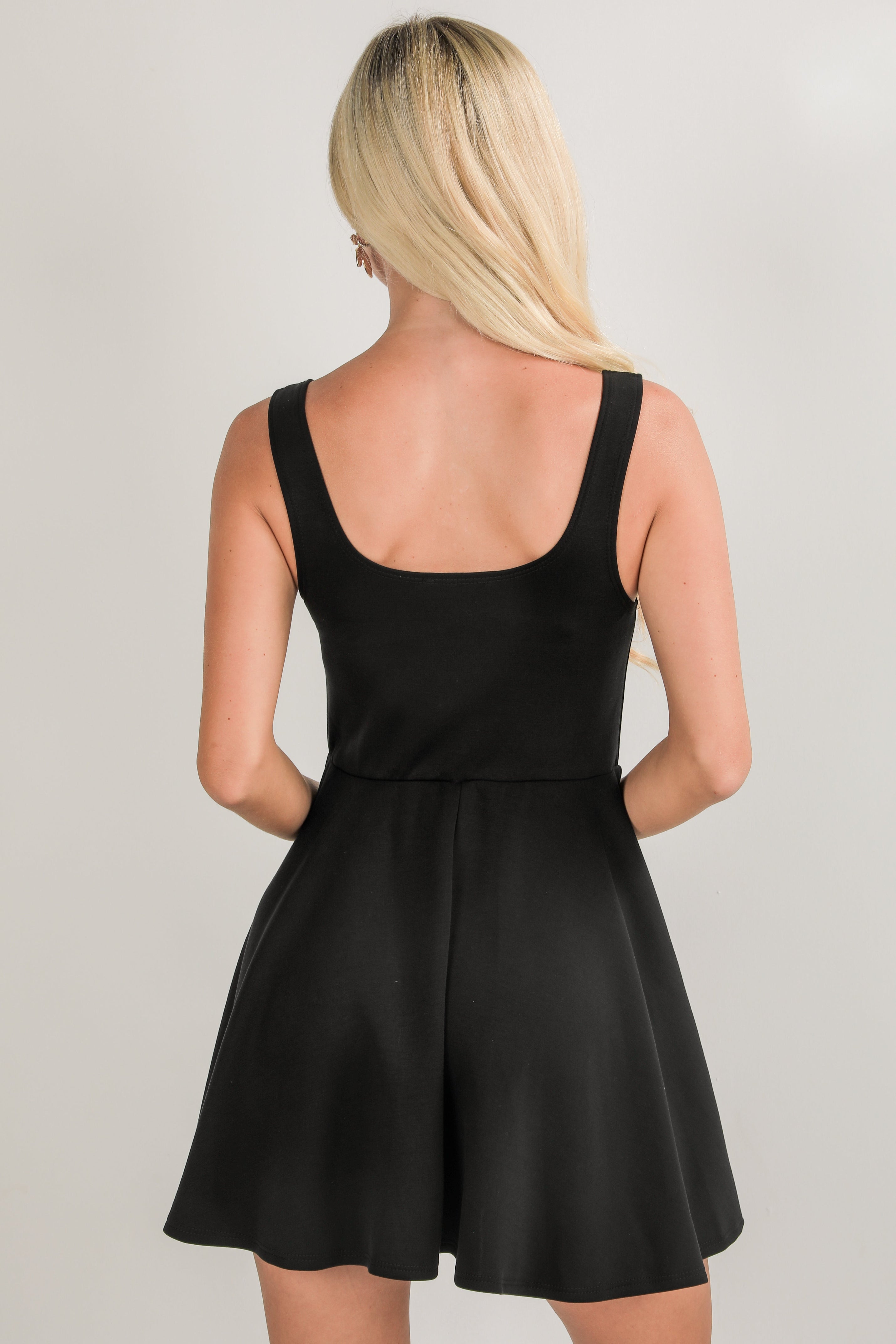 Black dress worn by a person on a plain background