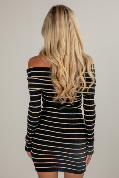 Black and white striped dress worn by a person with long blonde hair on a plain background