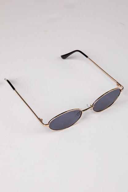 Sunglasses with gold frame and dark lenses on a white background