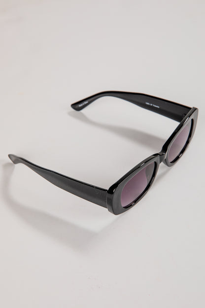 Black sunglasses with purple lenses on a light gray background