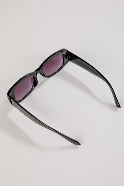 Black sunglasses with purple lenses on a light gray background