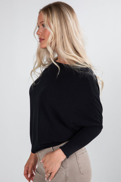 Woman wearing a black long-sleeve top against a white background