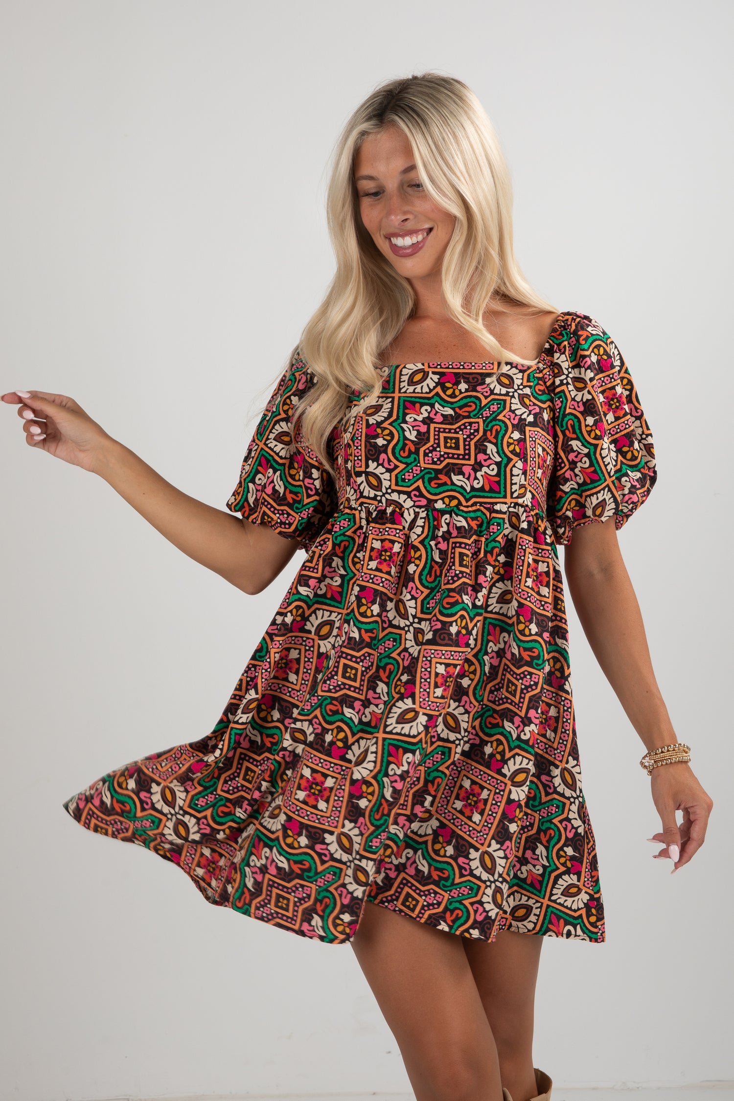 Woman wearing a patterned dress against a plain background