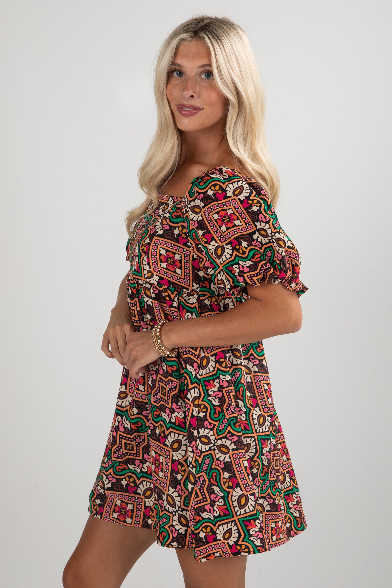 Woman wearing a patterned dress on a plain background