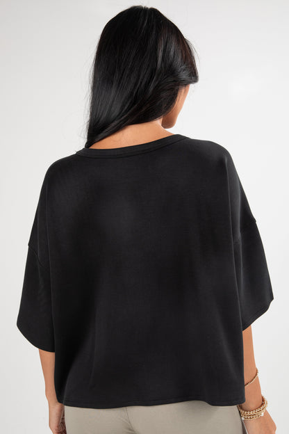 Person wearing a black oversized shirt on a white background