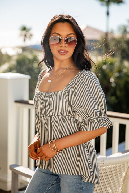 Woman wearing a striped top and sunglasses outdoors