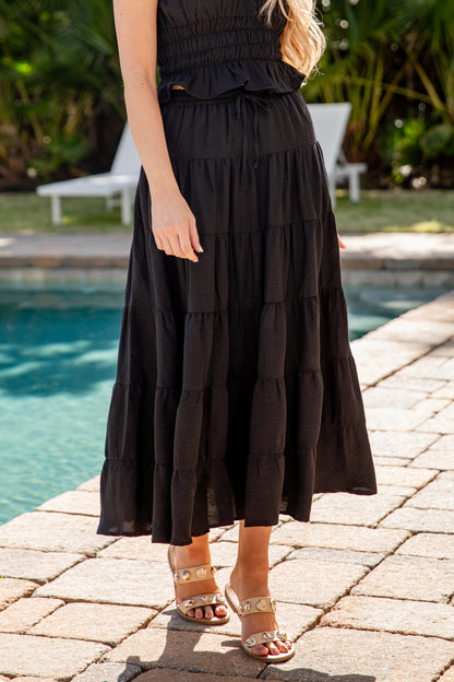 Woman wearing a black dress by a poolside