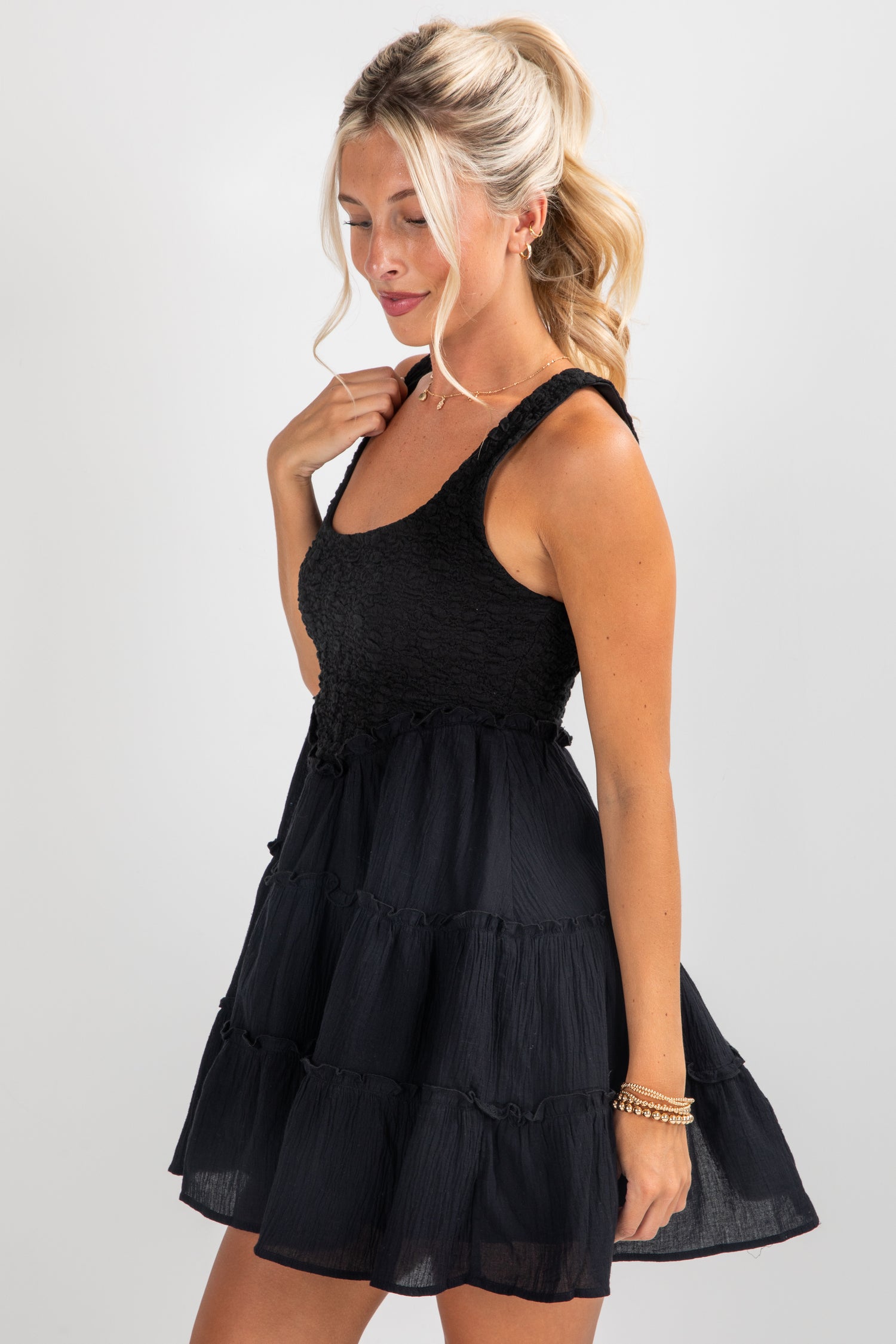 Woman wearing a black dress against a plain background