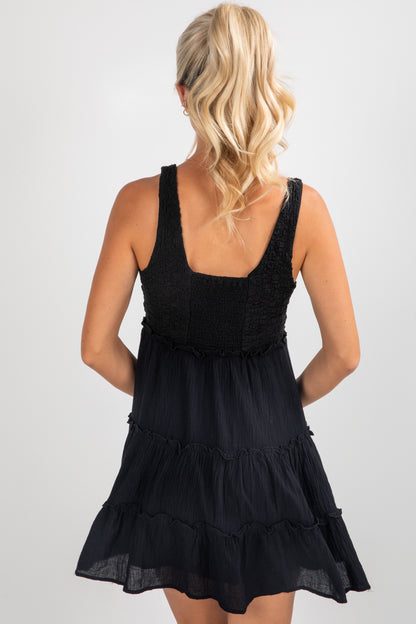 Black tiered dress worn by a person on a plain background