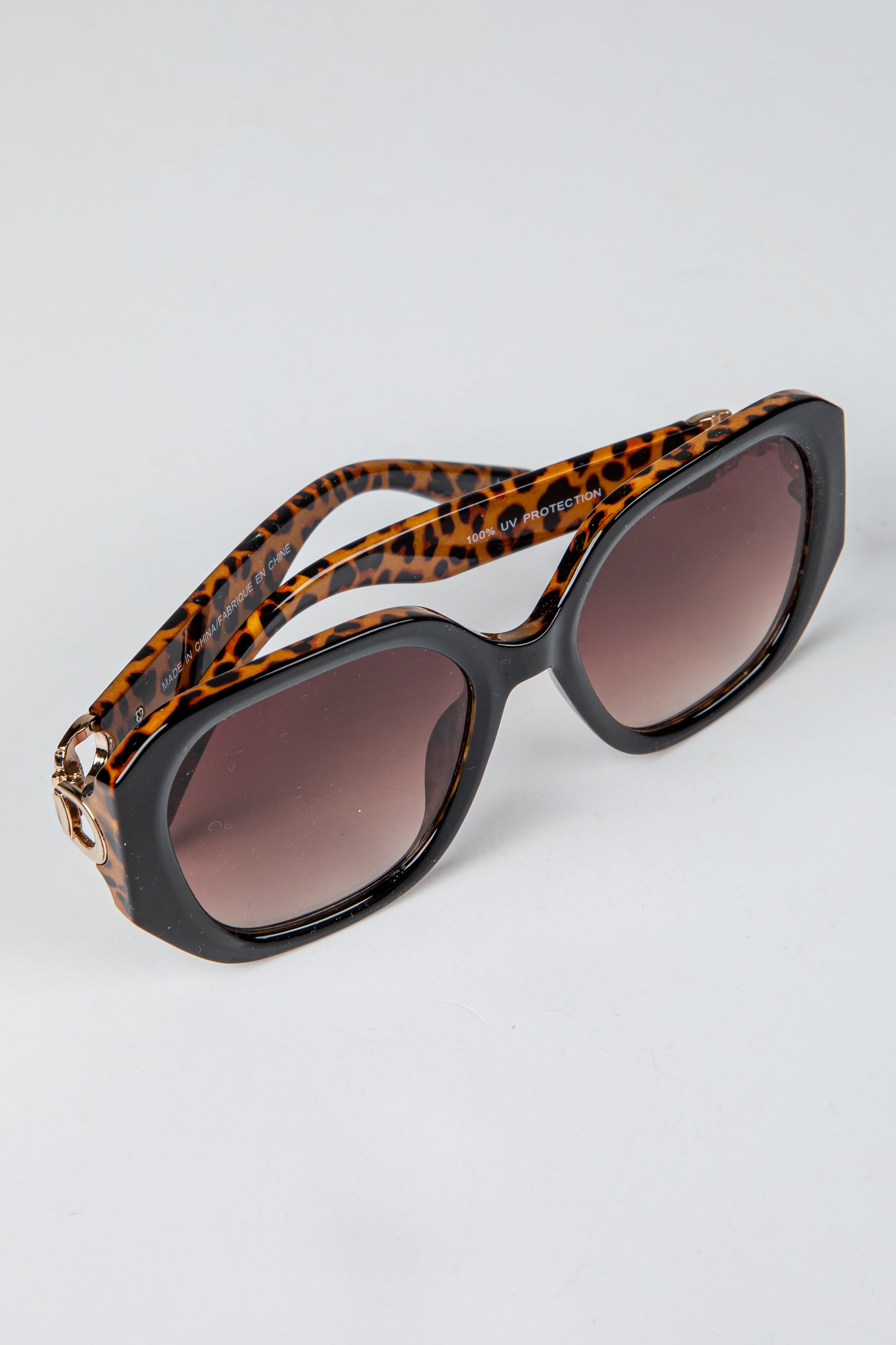 Sunglasses with leopard print frame and brown lenses on a light gray background