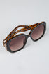 Sunglasses with leopard print frame and brown lenses on a light gray background