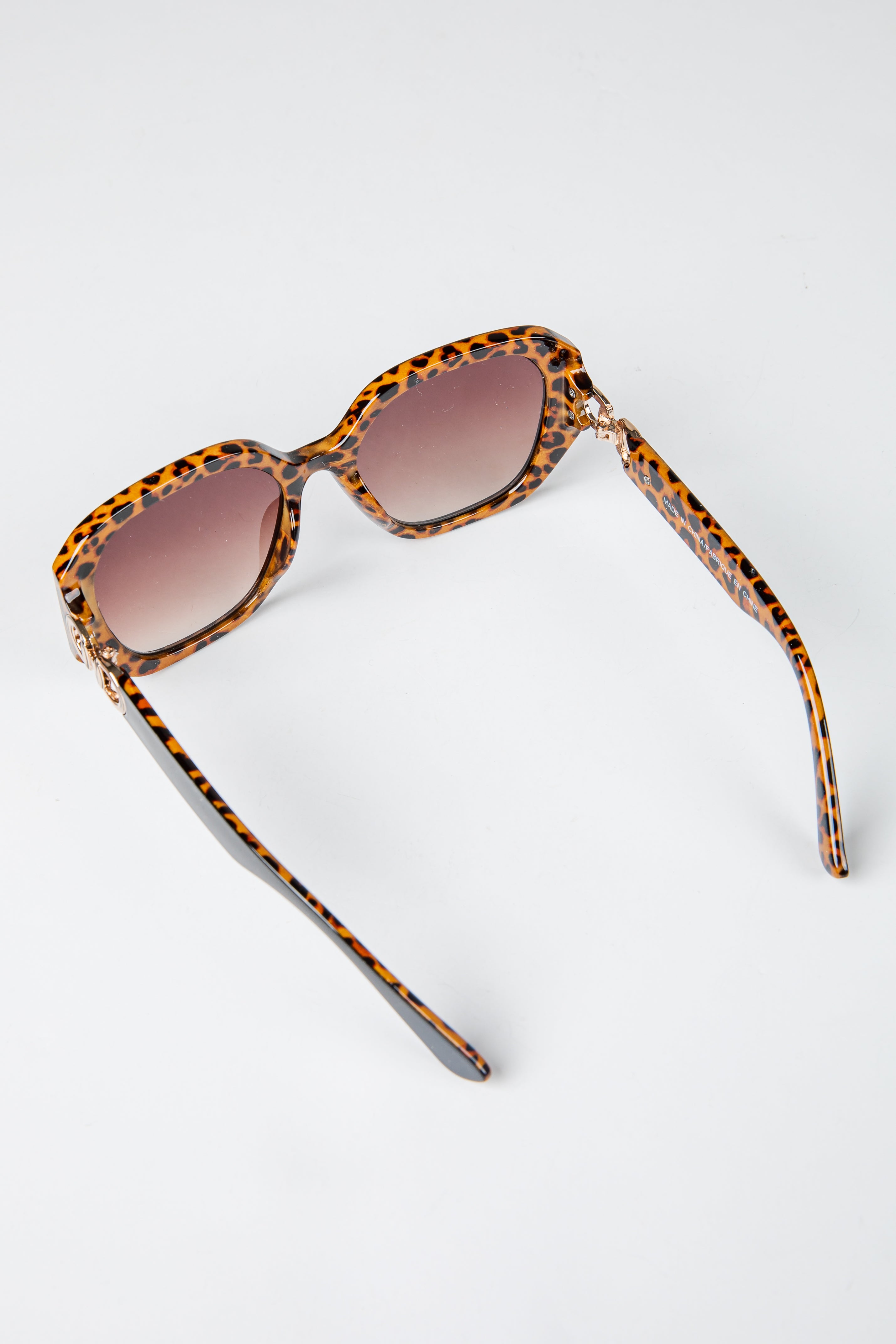 Sunglasses with tortoiseshell frame and brown lenses on a white background