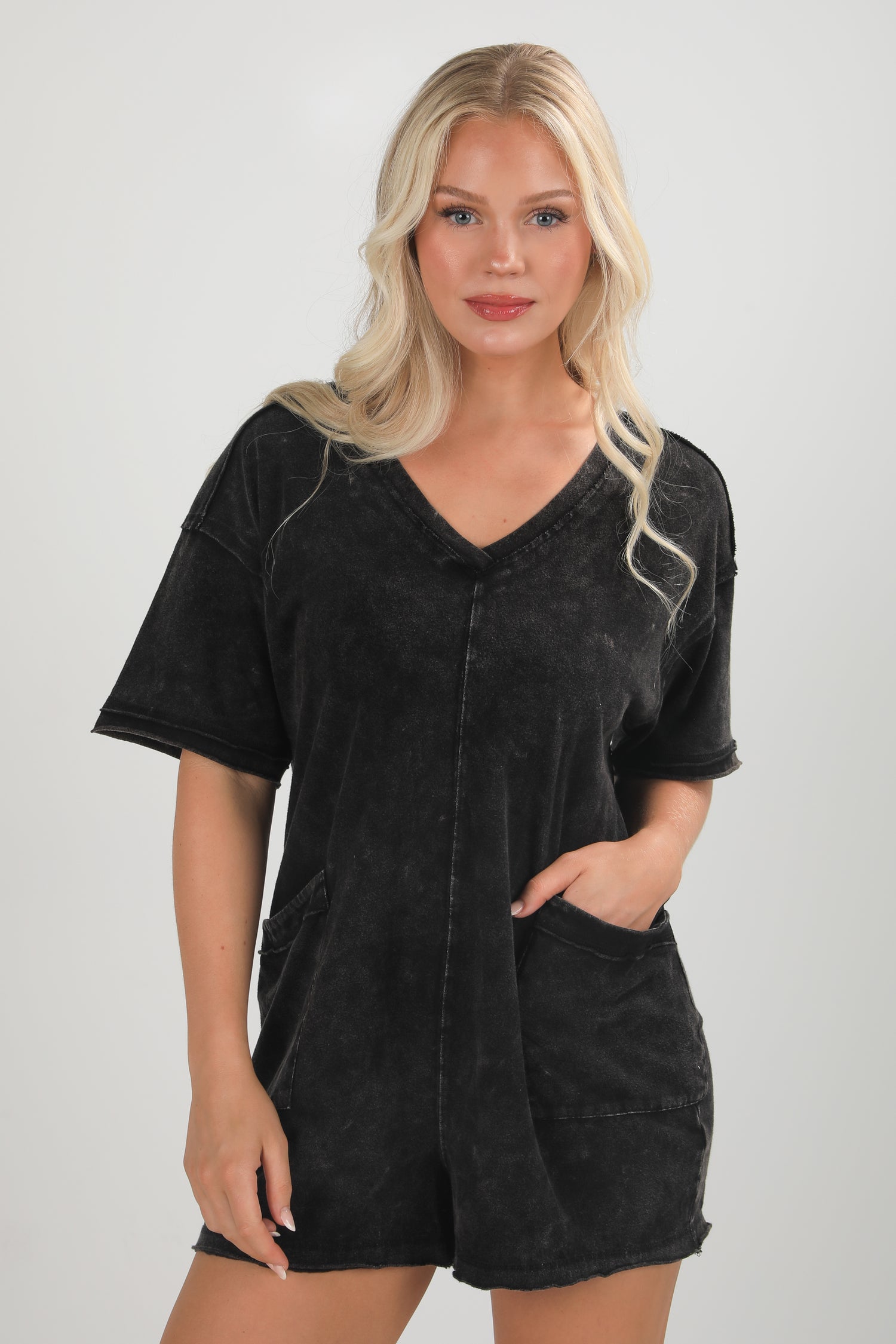 Woman wearing a black oversized shirt with a plain background