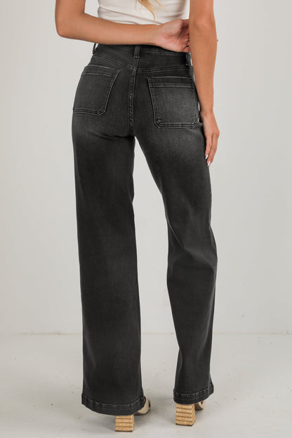 Person wearing black jeans on a plain background