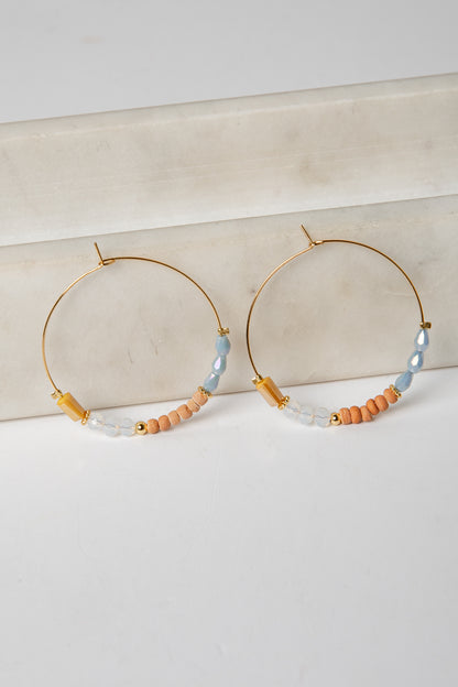 Hoop earrings with beaded accents on a light background