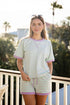 Woman wearing a striped shirt and shorts set with a blurred outdoor background