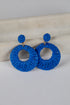Blue hoop earrings on a light gray surface