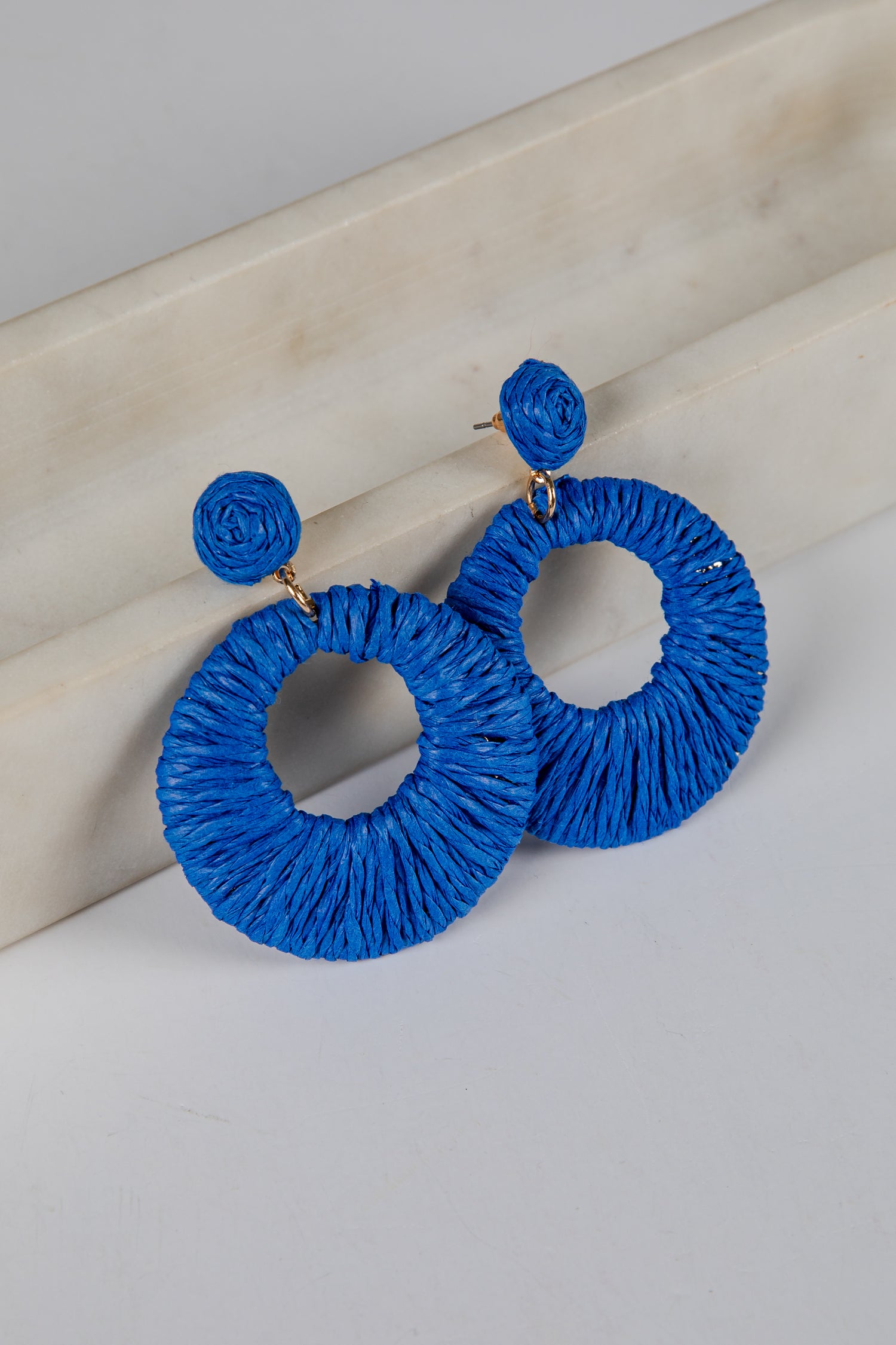 Blue hoop earrings on a light wooden surface