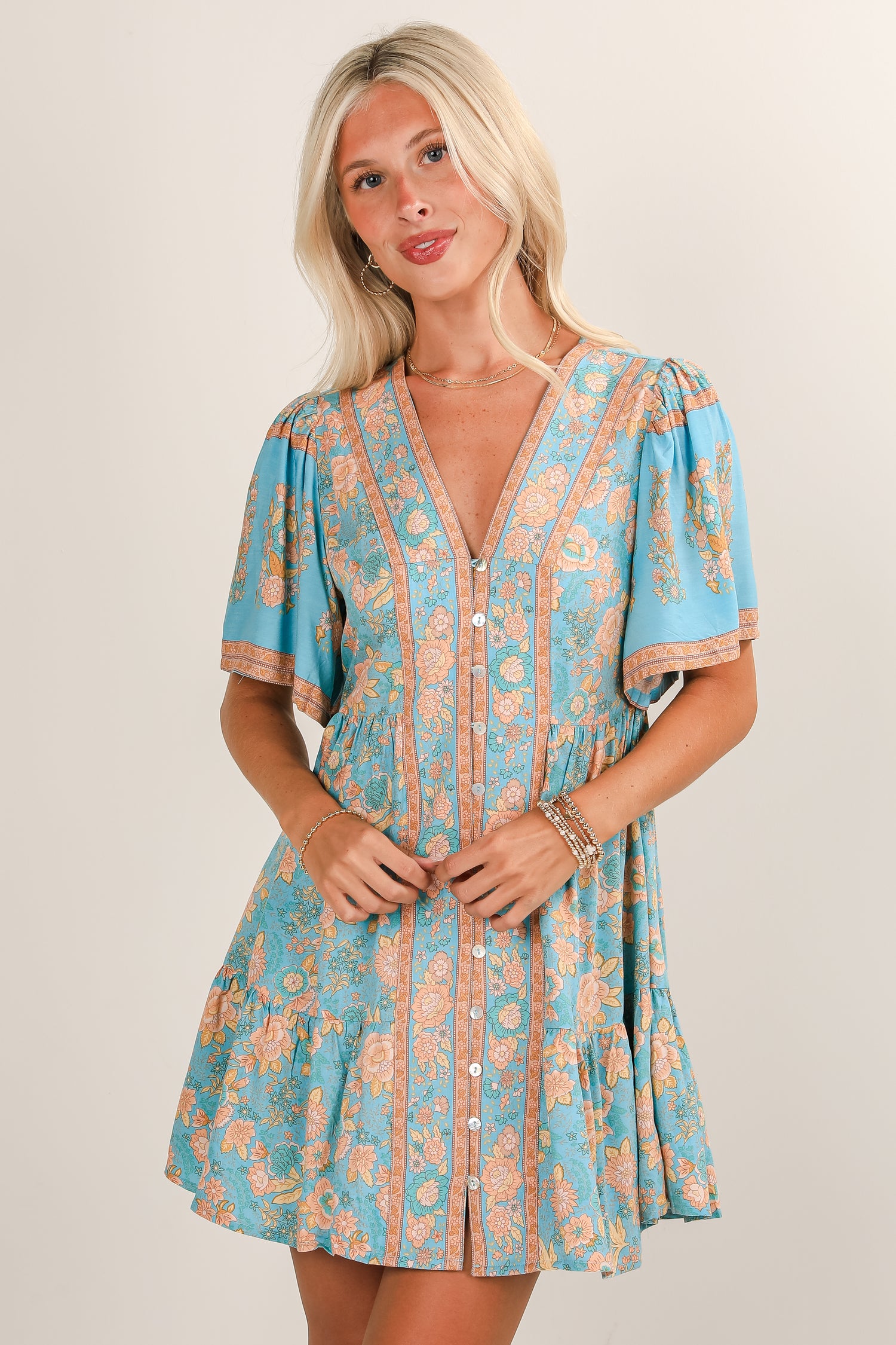 Woman wearing a blue and orange patterned dress on a plain background