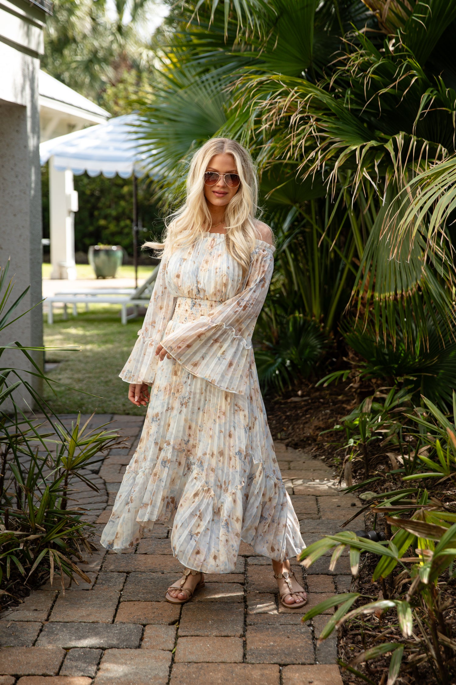 Woman in a floral dress standing in a garden setting