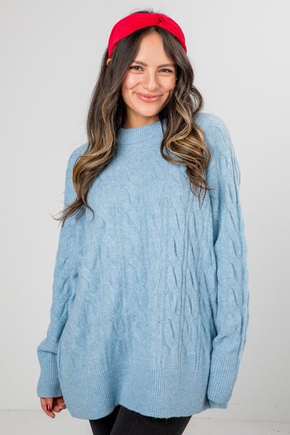Woman wearing a blue sweater and red headband against a white background